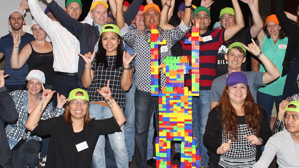 Employees assembling toys for children during The Toy Factory team building event.