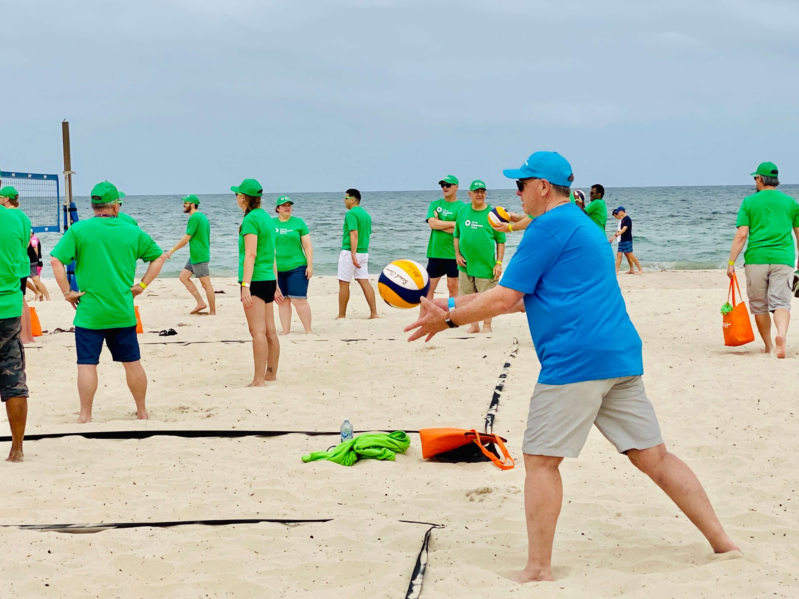 beach-team-building-volleyball-challenge Colleagues take part in a beach volleyball challenge during a corporate beach team building event by the sea.